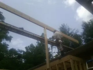 Carpenter setting a ridge beam over a new addition frame — Ice Dam Removal by Roofing Brothers in Carmel By The Sea