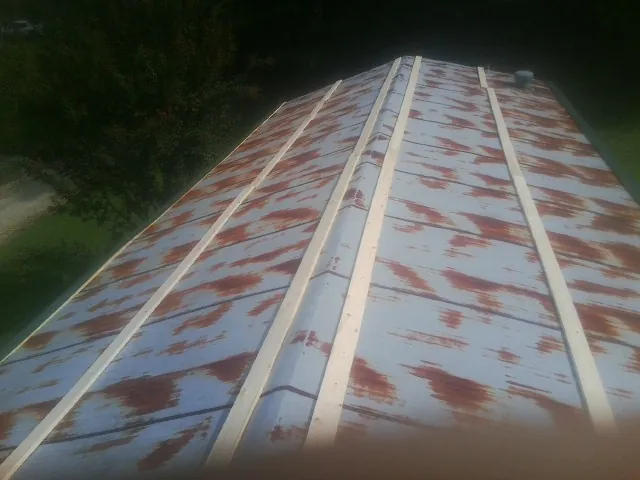 Rusted metal roof panels with new wood purlins before replacement — Storm Damage Roof Repair in Carmel By The Sea by Roofing Brothers