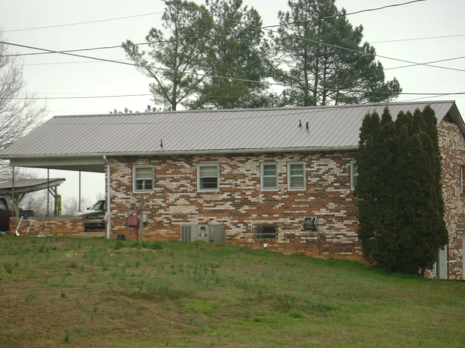Gray metal roof on a brick split level home with a carport in Carmel By The Sea