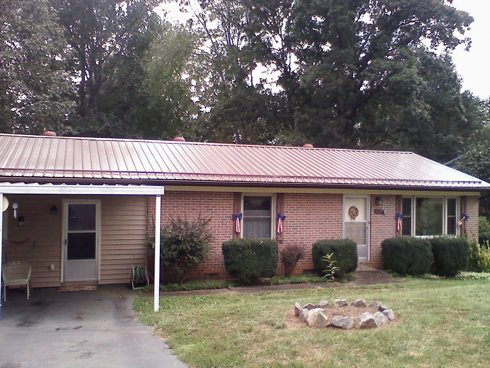 Bronze metal roof and carport on a brick ranch home — Roof Repair work by our crew in Carmel By The Sea