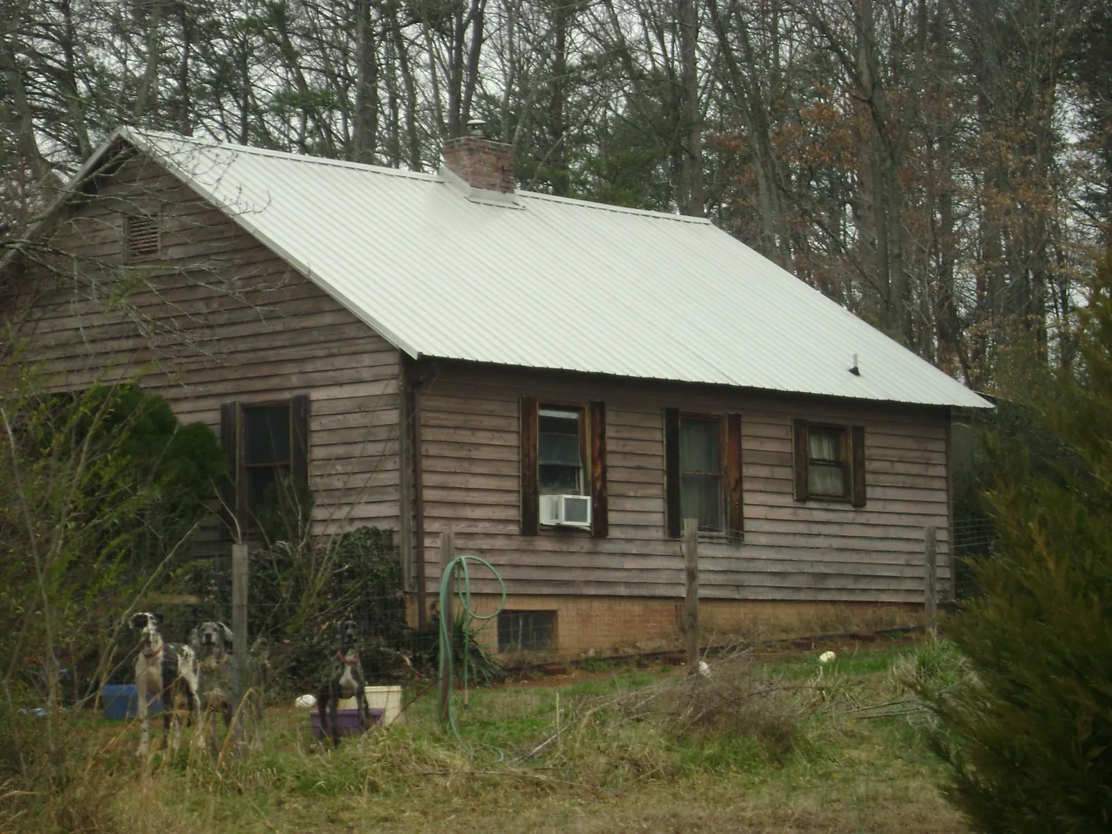 White metal roof on an old wood sided farmhouse, from a Metal Roof Installation job in Carmel By The Sea